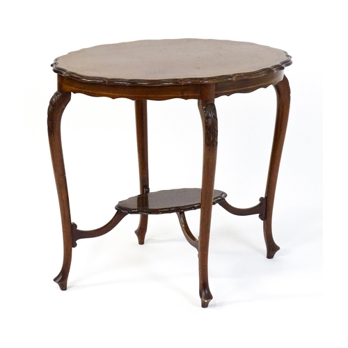 1472 - An Edwardian mahogany occasional table with a shaped inlaid top above four carved cabriole legs unit... 