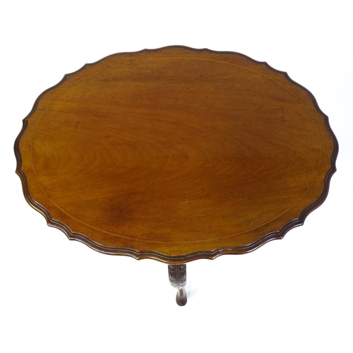 1472 - An Edwardian mahogany occasional table with a shaped inlaid top above four carved cabriole legs unit... 