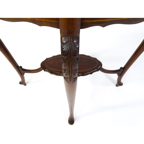 1472 - An Edwardian mahogany occasional table with a shaped inlaid top above four carved cabriole legs unit... 