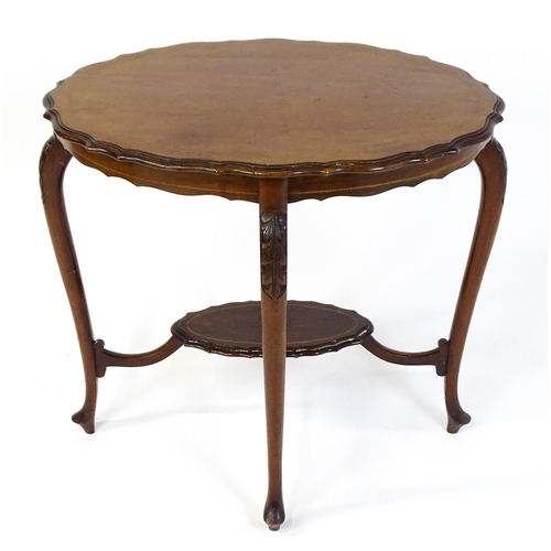 1472 - An Edwardian mahogany occasional table with a shaped inlaid top above four carved cabriole legs unit... 