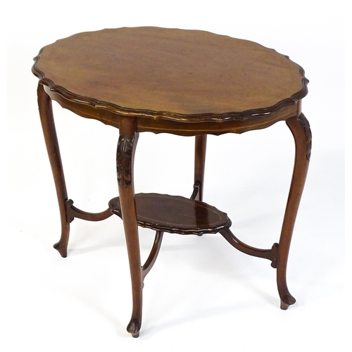 1472 - An Edwardian mahogany occasional table with a shaped inlaid top above four carved cabriole legs unit... 