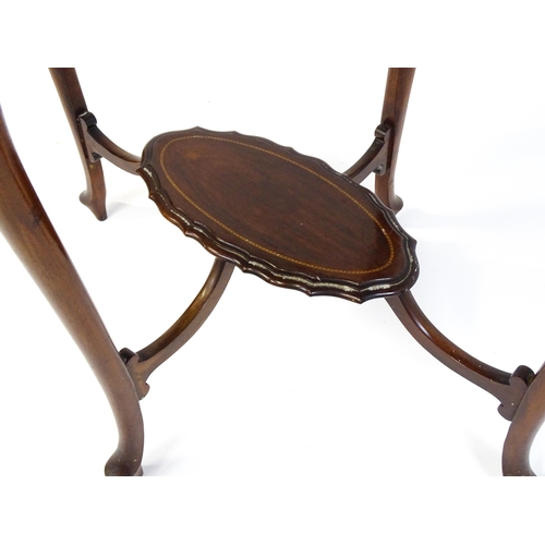 1472 - An Edwardian mahogany occasional table with a shaped inlaid top above four carved cabriole legs unit... 