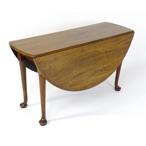 1473 - A Georgian mahogany drop flap table with two drop demi lune drop leaves raised on turned legs termin... 