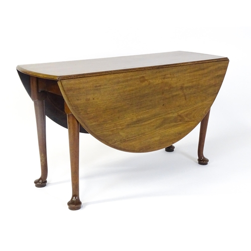 1473 - A Georgian mahogany drop flap table with two drop demi lune drop leaves raised on turned legs termin... 