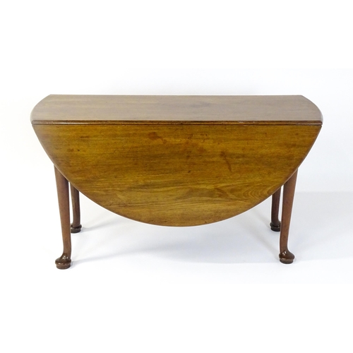 1473 - A Georgian mahogany drop flap table with two drop demi lune drop leaves raised on turned legs termin... 