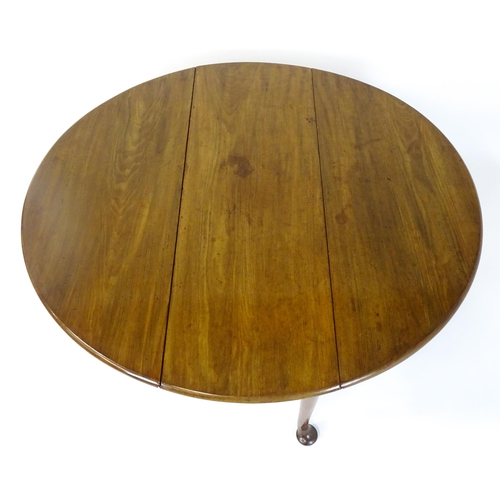 1473 - A Georgian mahogany drop flap table with two drop demi lune drop leaves raised on turned legs termin... 