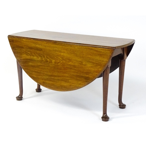 1473 - A Georgian mahogany drop flap table with two drop demi lune drop leaves raised on turned legs termin... 