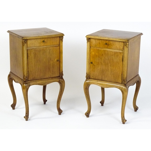 1474 - A pair of early / mid 20thC walnut bedside cabinets, each having a single short drawer, panelled cup... 