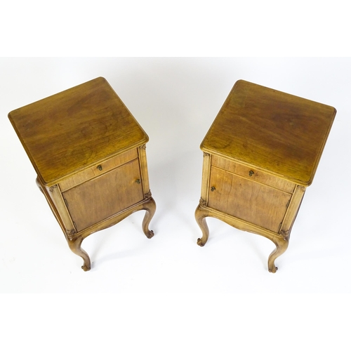 1474 - A pair of early / mid 20thC walnut bedside cabinets, each having a single short drawer, panelled cup... 