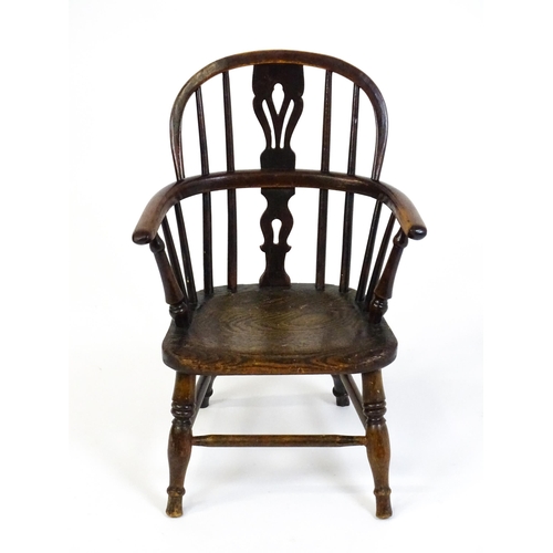 1475 - A 19thC child's yew wood Windsor chair by George Nicholson of Rockley, the chair having a pierced ba... 