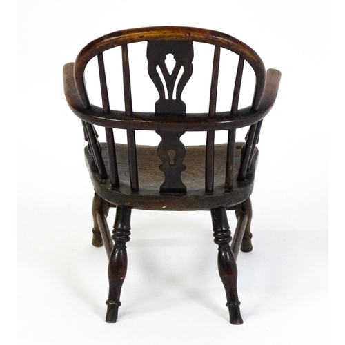 1475 - A 19thC child's yew wood Windsor chair by George Nicholson of Rockley, the chair having a pierced ba... 