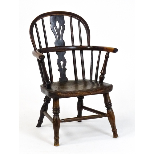 1475 - A 19thC child's yew wood Windsor chair by George Nicholson of Rockley, the chair having a pierced ba... 