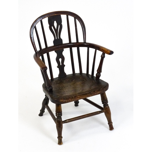 1475 - A 19thC child's yew wood Windsor chair by George Nicholson of Rockley, the chair having a pierced ba... 