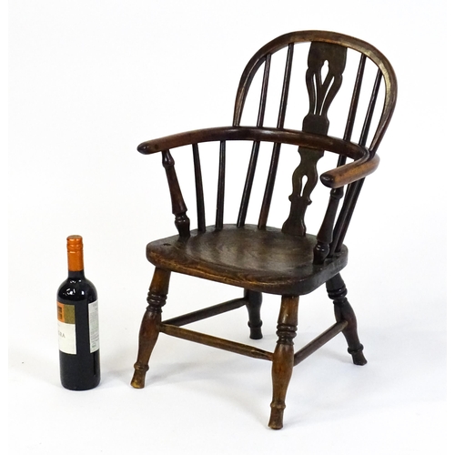 1475 - A 19thC child's yew wood Windsor chair by George Nicholson of Rockley, the chair having a pierced ba... 