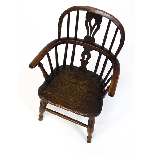 1475 - A 19thC child's yew wood Windsor chair by George Nicholson of Rockley, the chair having a pierced ba... 