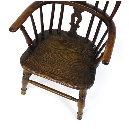 1475 - A 19thC child's yew wood Windsor chair by George Nicholson of Rockley, the chair having a pierced ba... 