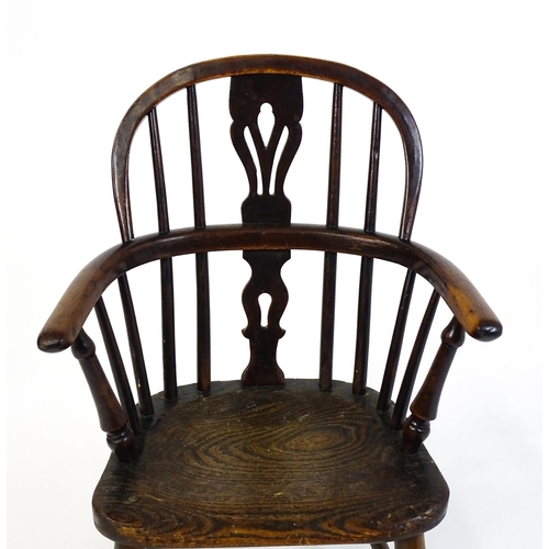 1475 - A 19thC child's yew wood Windsor chair by George Nicholson of Rockley, the chair having a pierced ba... 