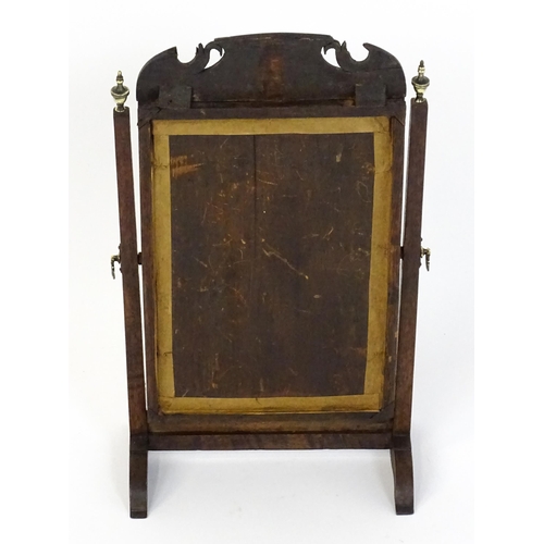 1477 - A 19thC walnut toilet mirror with a moulded frame, tapering uprights surmounted by brass finials and... 