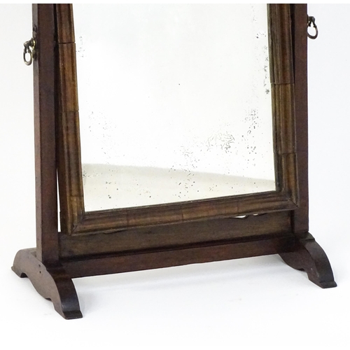 1477 - A 19thC walnut toilet mirror with a moulded frame, tapering uprights surmounted by brass finials and... 