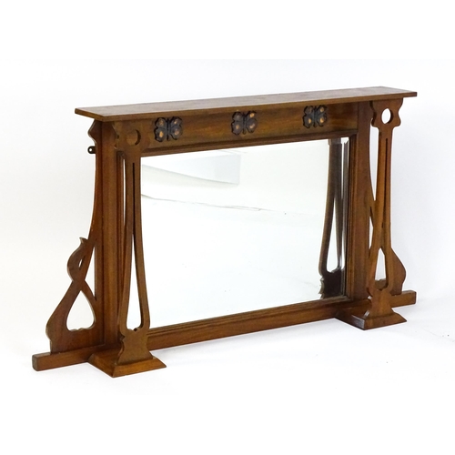 1478 - A late 19thC / early 20thC walnut Arts & Crafts over mantel mirror with pierced decorative brackets,... 