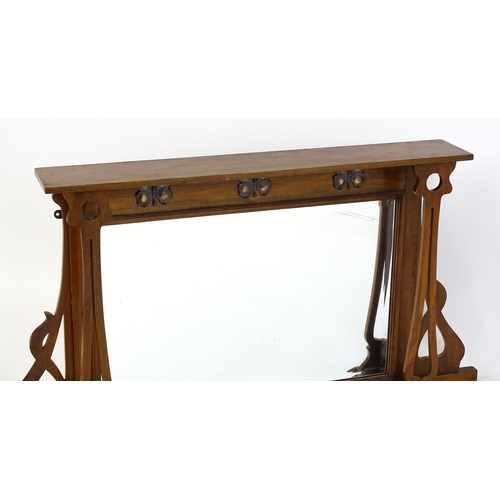 1478 - A late 19thC / early 20thC walnut Arts & Crafts over mantel mirror with pierced decorative brackets,... 