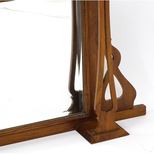 1478 - A late 19thC / early 20thC walnut Arts & Crafts over mantel mirror with pierced decorative brackets,... 