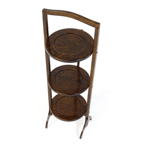 1480 - An early / mid 20thC folding oak cake stand with three circular dished tiers. 34