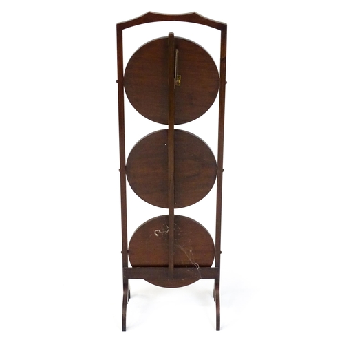 1481 - An early / mid 20thC mahogany folding cake stand, having three circular tiers with beadwork style mo... 