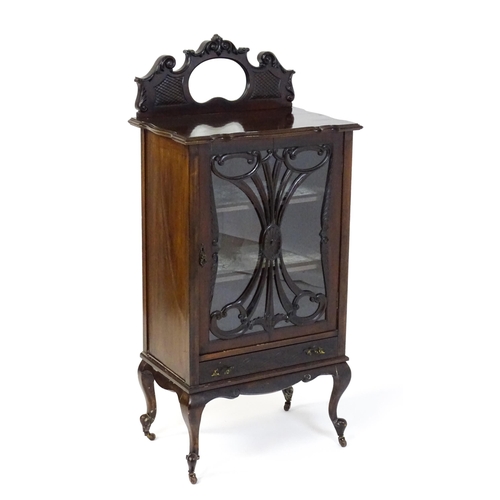 1483 - An Edwardian mahogany display cabinet with a mirrored upstand above a single glazed door with pierce... 