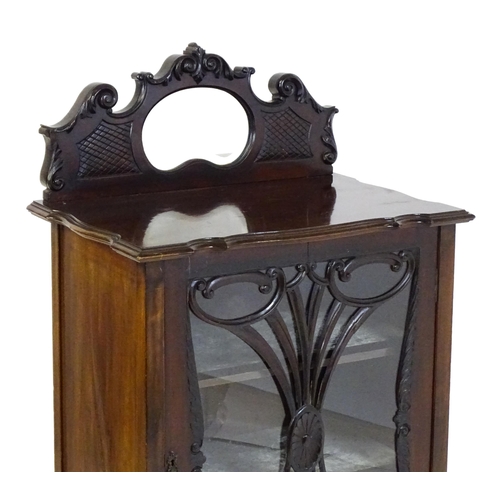 1483 - An Edwardian mahogany display cabinet with a mirrored upstand above a single glazed door with pierce... 