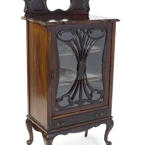 1483 - An Edwardian mahogany display cabinet with a mirrored upstand above a single glazed door with pierce... 