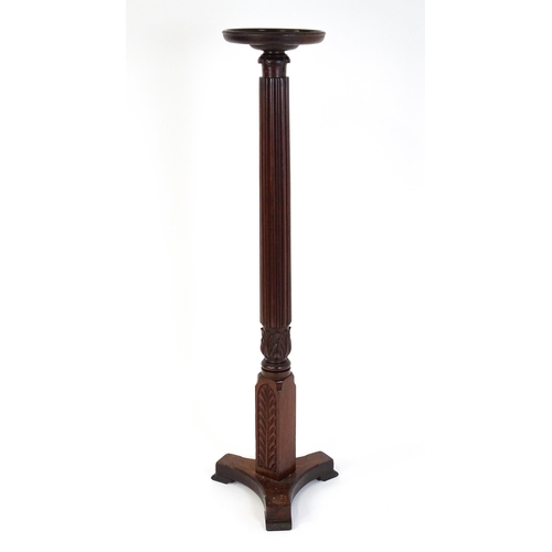 1485 - An early 20thC mahogany torchiere with a dished top above a turned reeded column with carved floral ... 