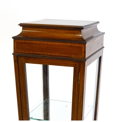 1486 - A late 19thC / early 20thC mahogany display cabinet with a crossbanded top above a tapering body rai... 