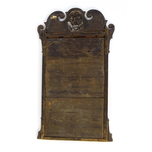 1488 - An 18thC walnut mirror with a scrolled top and gilt pierced floral decoration above a gilt moulded s... 