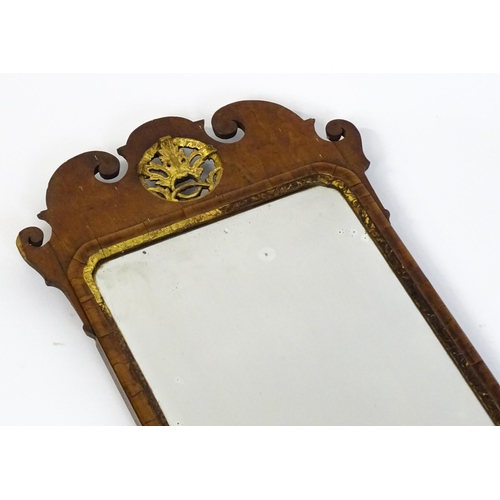 1488 - An 18thC walnut mirror with a scrolled top and gilt pierced floral decoration above a gilt moulded s... 