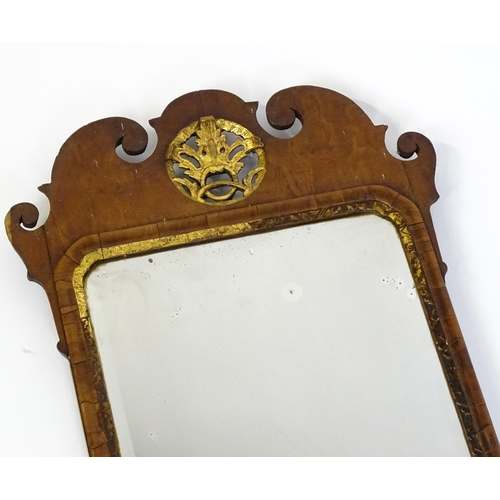 1488 - An 18thC walnut mirror with a scrolled top and gilt pierced floral decoration above a gilt moulded s... 