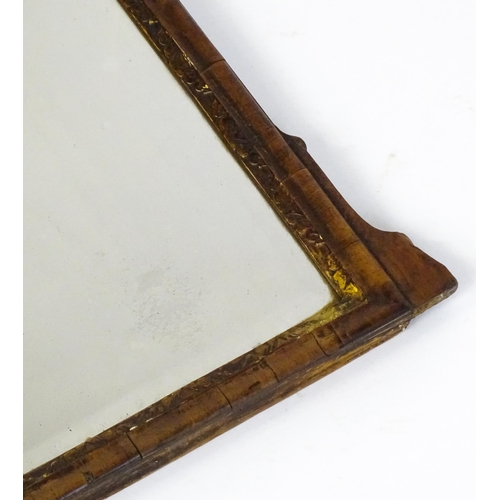 1488 - An 18thC walnut mirror with a scrolled top and gilt pierced floral decoration above a gilt moulded s... 