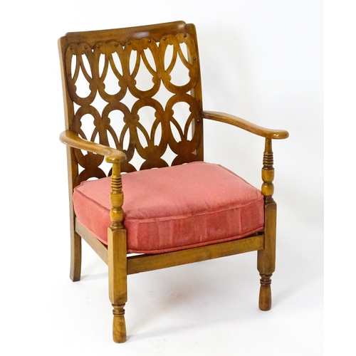 1490 - A mid 20thC elbow chair by Birchcraft of High Wycombe, the back rest having repeating pierced decora... 