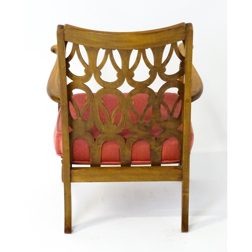 1490 - A mid 20thC elbow chair by Birchcraft of High Wycombe, the back rest having repeating pierced decora... 