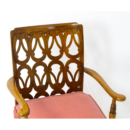 1490 - A mid 20thC elbow chair by Birchcraft of High Wycombe, the back rest having repeating pierced decora... 