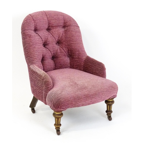 1491 - An early 20thC nursing chair with a deep buttoned backrest above a sprung seat raised on turned, tap... 