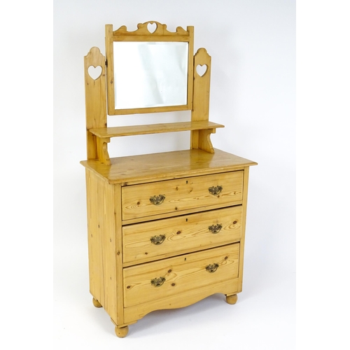 1493 - An early 20thC pine dressing table decorated with pierced heart shaped motifs, having a bevelled mir... 