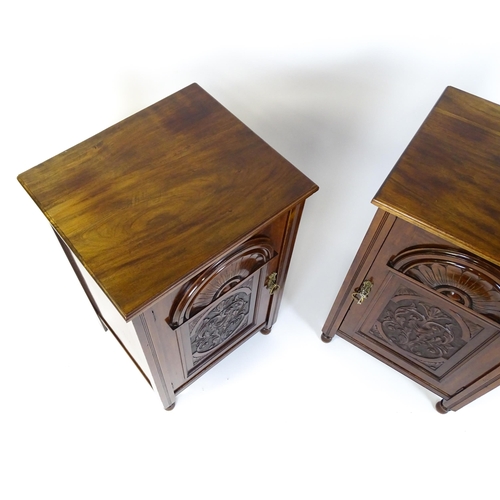 1495 - A pair of Edwardian walnut pedestals with moulded tops above carved panelled doors raised on turned ... 