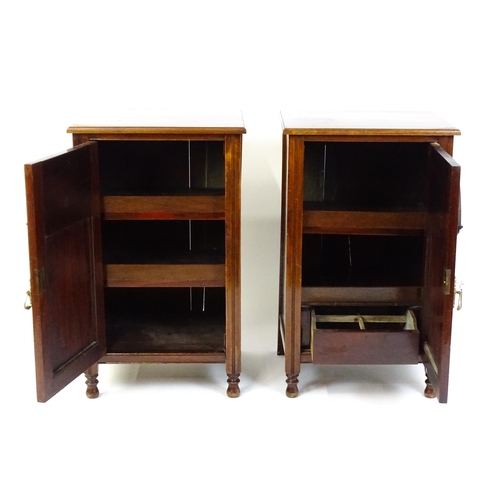 1495 - A pair of Edwardian walnut pedestals with moulded tops above carved panelled doors raised on turned ... 