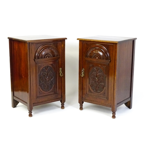 1495 - A pair of Edwardian walnut pedestals with moulded tops above carved panelled doors raised on turned ... 