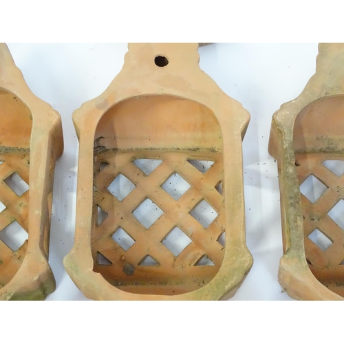 1306 - Assorted terracotta items comprising five Mediterranean-style garden wall light covers, together wit... 