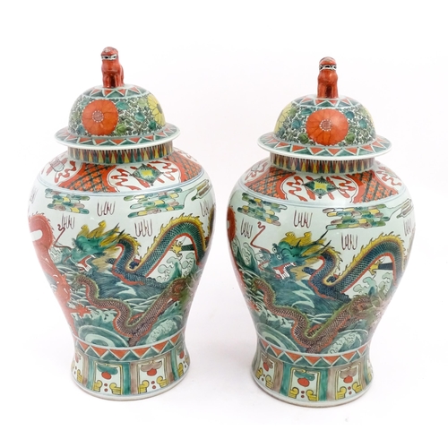 4 - A large pair of Chinese ginger jars decorated with dragons above stylised waves, bordered by flowers... 