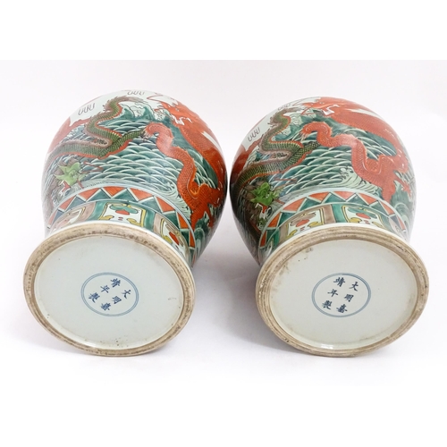 4 - A large pair of Chinese ginger jars decorated with dragons above stylised waves, bordered by flowers... 