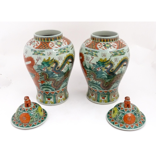 4 - A large pair of Chinese ginger jars decorated with dragons above stylised waves, bordered by flowers... 