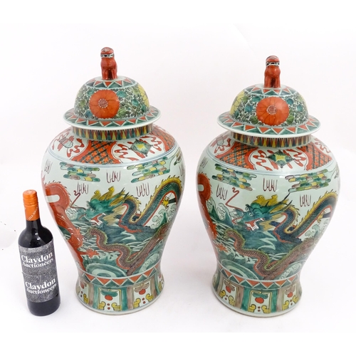 4 - A large pair of Chinese ginger jars decorated with dragons above stylised waves, bordered by flowers... 